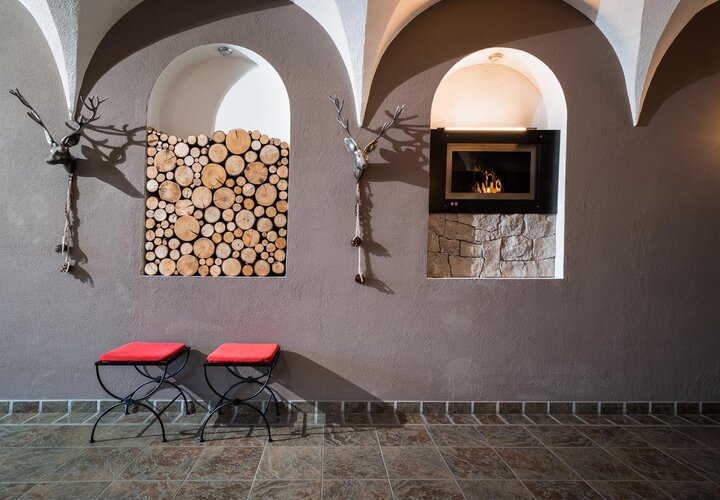 Mauer mit Ofen und aufgeschlichtetem Holz